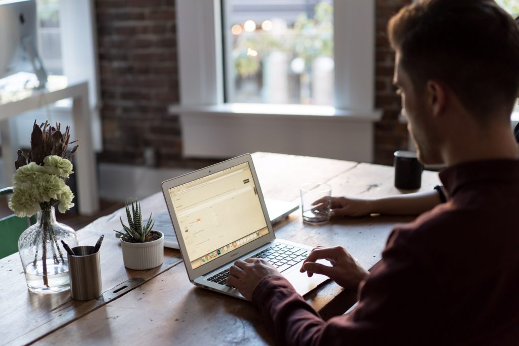 man working on his laptop using effective time management strategies